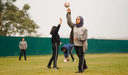 Student throws a ball during a game on the school field