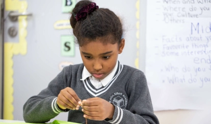  AKA Maputo student works on an art project inside a classroom.