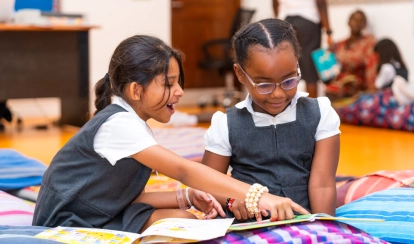 Two AKA Mombasa Junior School students sharing a book in the library.