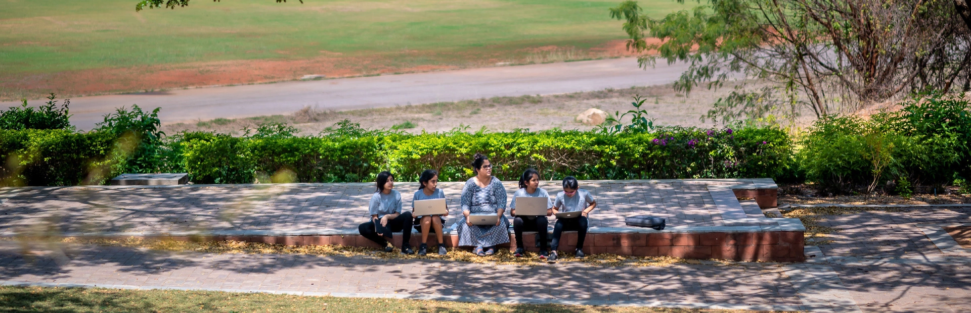  A teacher smiles as she assists two young students shaping clay letters during a classroom activity, with colourful learning materials and displays visible in the background44666666666666