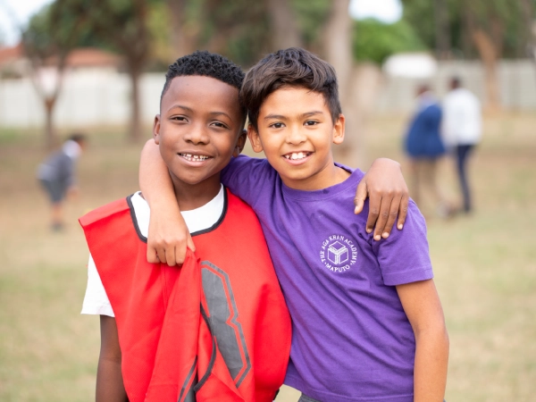 Two AKA Maputo students standing outside together.