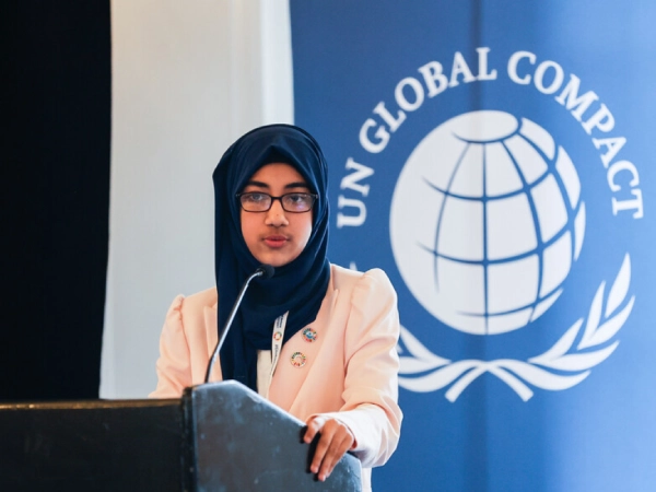 Faatiha stands at a podium, delivering a speech at the United Nations, where she is advocating for child rights and climate action