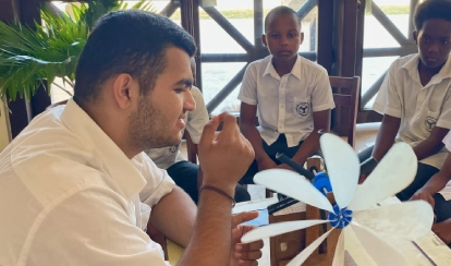 Student explaining a renewable energy prototype to other students.