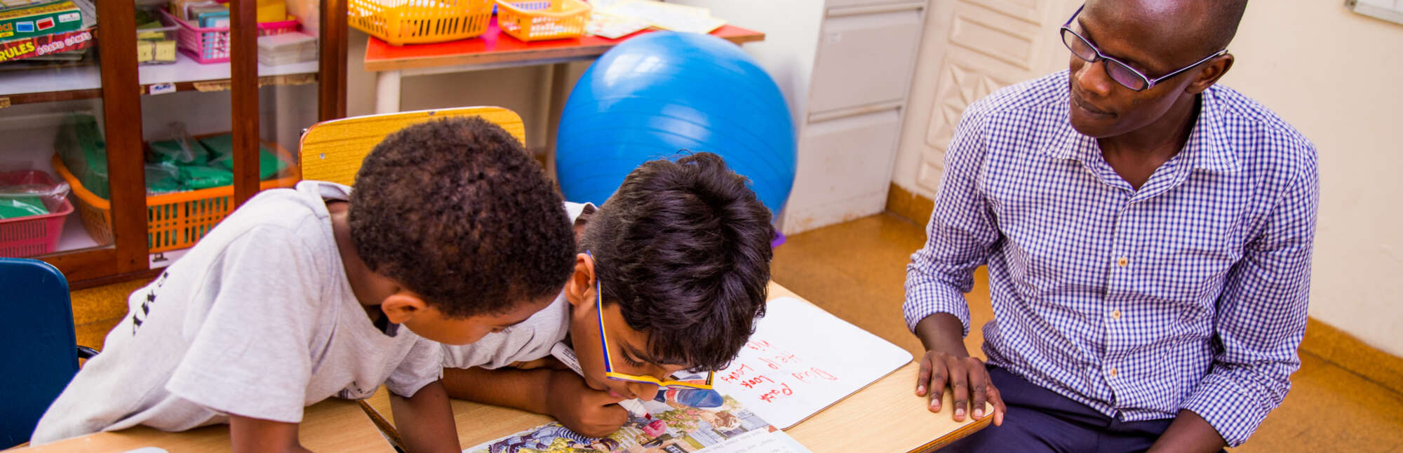Teacher sitting with two students.