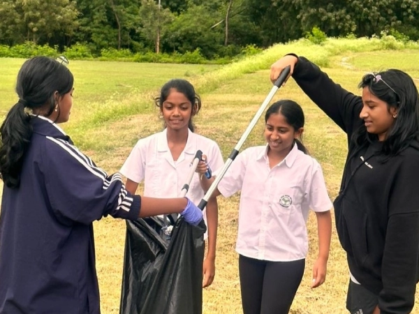  Students putting trash in a bag.