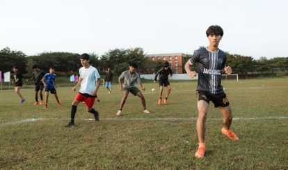 Students playing football.  