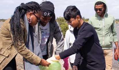 AKA Maputo students collect waste as part of a clean-up initiative for community service.