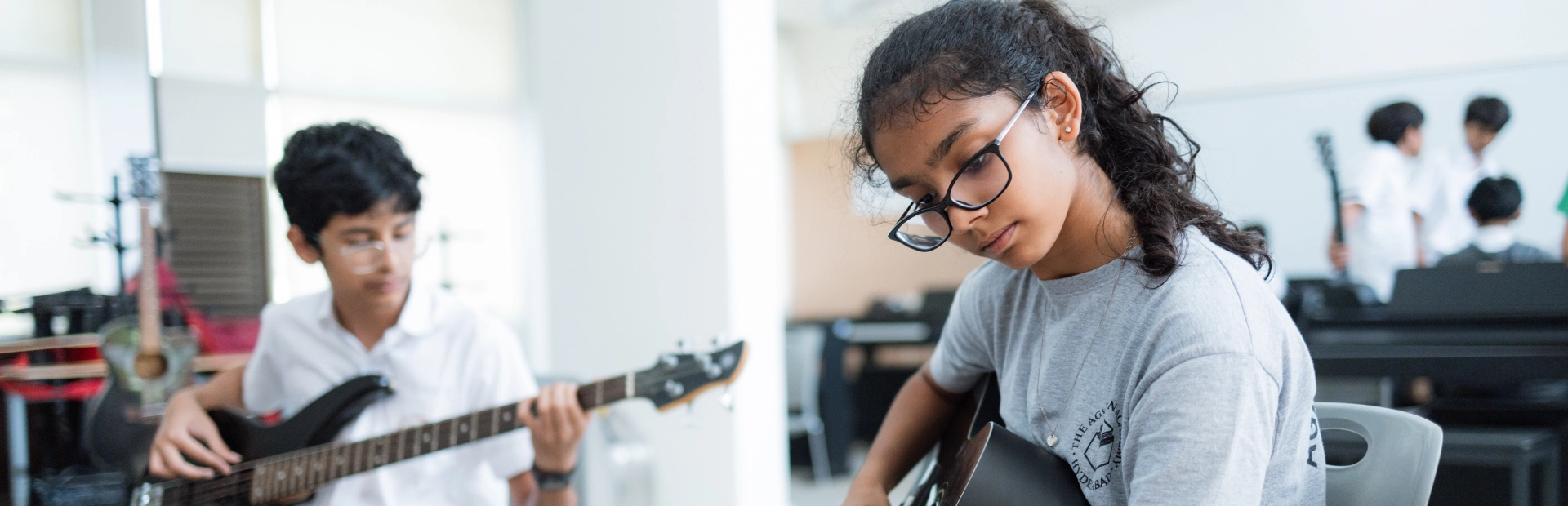 Students playing guitar in the music room.