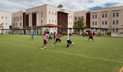 Students playing football on the astroturf.
