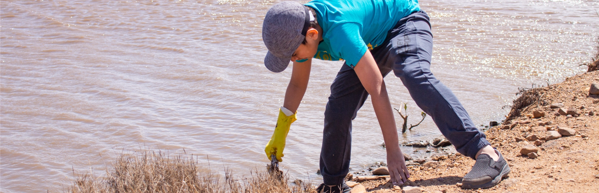 Grade 9 student mentors younger children in a service learning session on an outdoor court.
