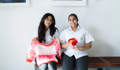 Students and a teacher work together on painting projects in an art classroom.