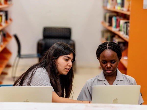 Students working on their laptops in the library.