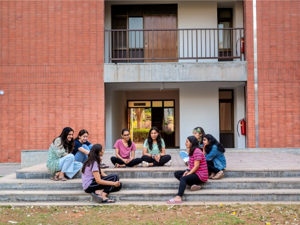 Residential students and dorm parent sitting outside the dorms.