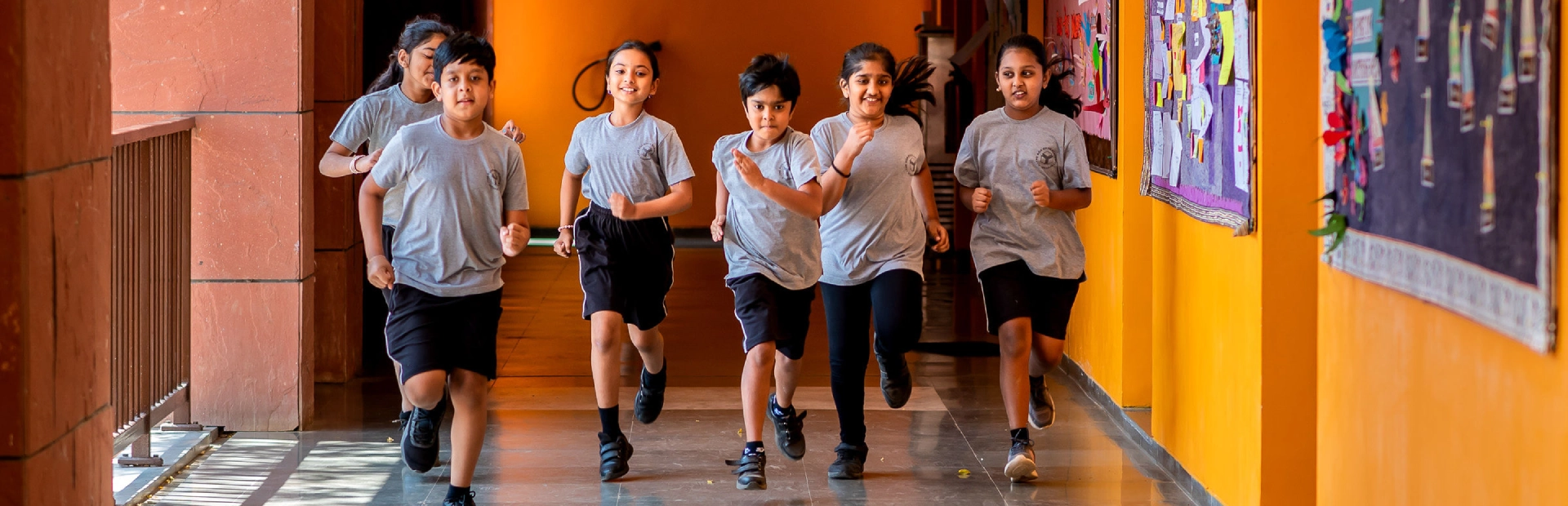 Students running in a corridor on campus.