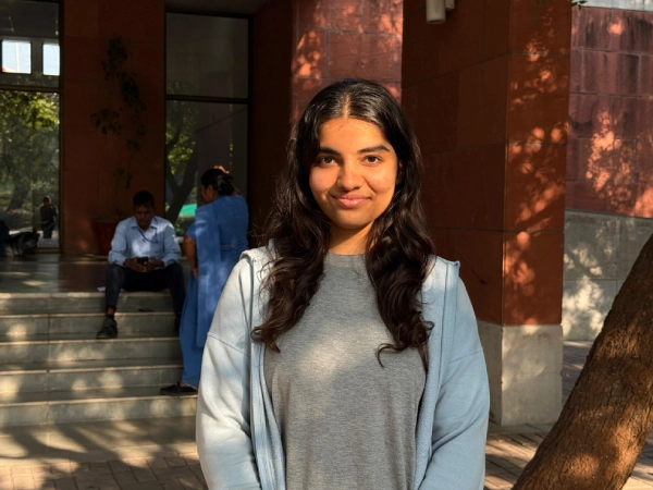 A parent stands in front of a “Welcome to our Unit Display” sign at AKA Dhaka.

